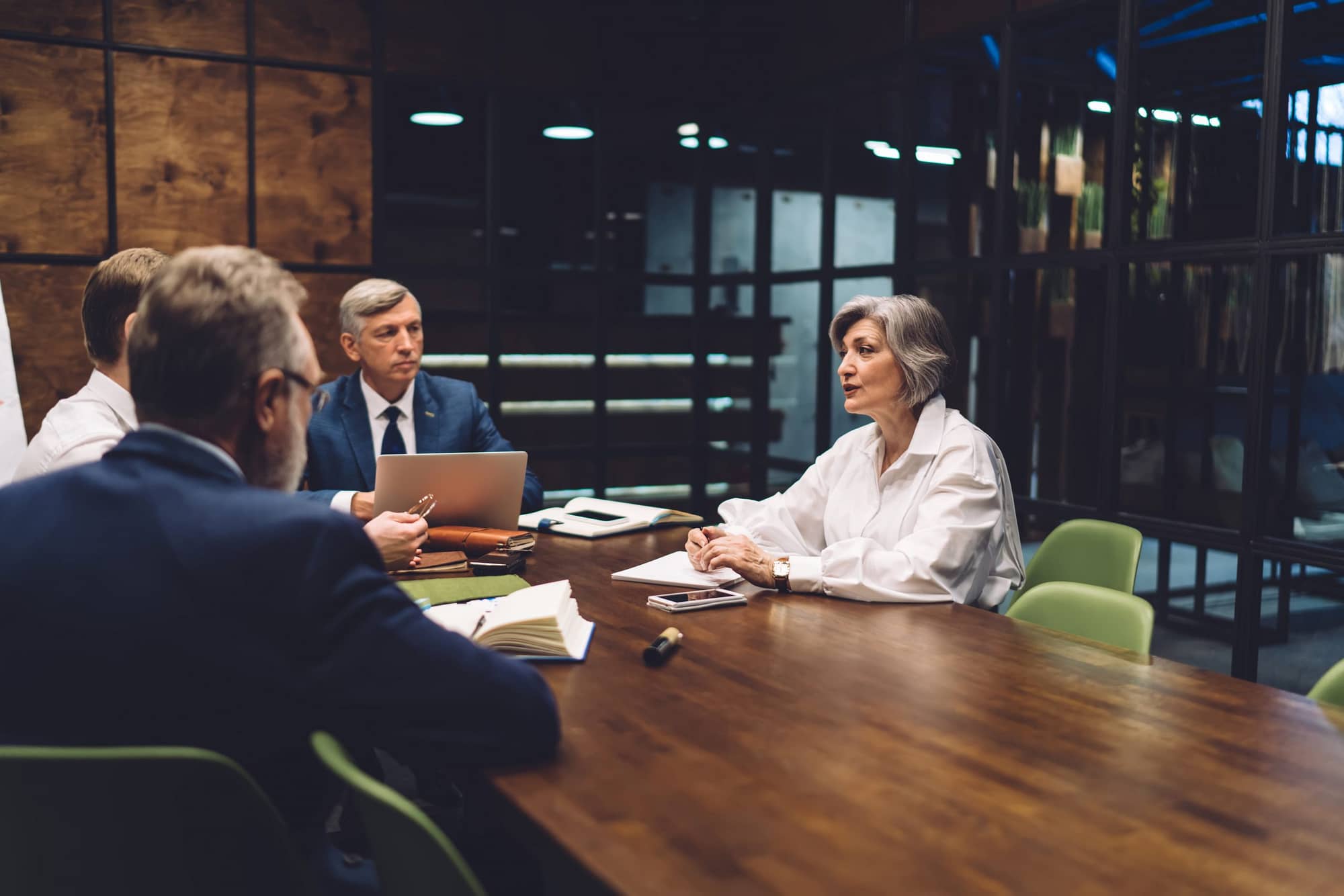 Group,Of,Serious,Colleagues,Sitting,At,Table,In,Modern,Workplace